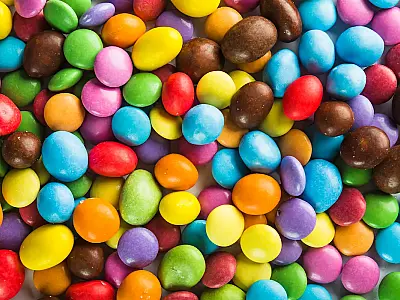 Conheça os bastidores dos M&M's: da criação na Guerra Civil Espanhola ao processo industrial das cascas coloridas que não derretem na mão.